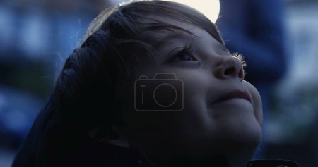 Foto de Niño espiritual mirando hacia arriba al cielo con ESPERANZA y FE. Primer plano del niño feliz mirando hacia arriba en la contemplación - Imagen libre de derechos