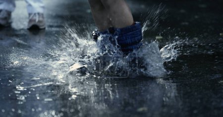 Foto de La revolución de Rainboot: los deliciosos saltos de los niños en los charcos crean un espectáculo impactante, capturado en cámara lenta de alta velocidad - Imagen libre de derechos