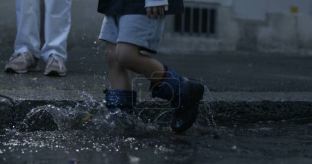 Photo for Kid's Rainboot Steps Sending Water Splashes Soaring, Captured at 800 fps on Sidewalk captured with high-speed camera - Royalty Free Image