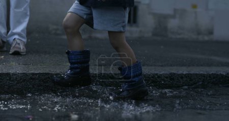 Téléchargez les photos : Les étapes Rainboot pour enfants Envoi de projections d'eau s'envolent, capturées à 800 ips sur le trottoir capturées avec une caméra à grande vitesse - en image libre de droit