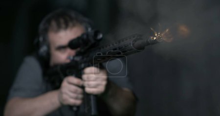 Foto de Hombre apuntando un rigle assult y disparando bala en alta velocidad de cámara lenta 800 fps - Imagen libre de derechos