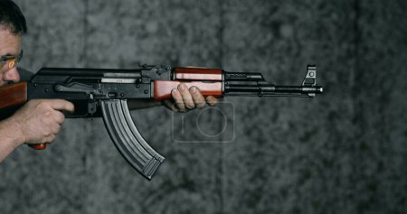 Téléchargez les photos : Tir à haute vitesse 800ips au ralenti avec AK-47, vue latérale de l'homme visant et tirant Kalachnikov fusil - en image libre de droit