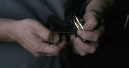 Photo for Close-up hand Reloading ammunition. Bullets into clip - Royalty Free Image