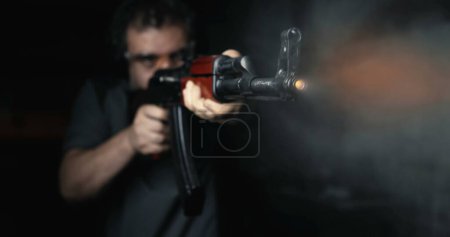 Téléchargez les photos : Homme visé avec Kalachnikov arme tirant au ralenti super à grande vitesse 800 ips, AK-47 fusil vue de face - en image libre de droit