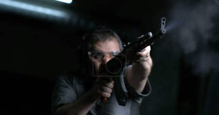 Téléchargez les photos : Tir à haute vitesse 800fps au ralenti avec AK-47, Homme visant et tirant Kalachnikov fusil, tir à faible angle - en image libre de droit