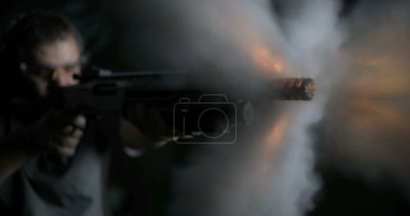 Photo for Close-up of man aiming and firing a shotgun in high-speed with smoke flying everywhere. powerful impact shot in slow-motion - Royalty Free Image