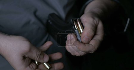 Téléchargez les photos : Action manuelle détaillée Rechargement de balles dans une pince à arme à feu, préparation de munitions Gros plan - en image libre de droit