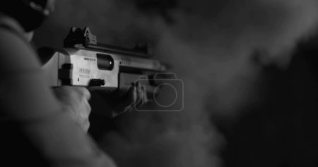 Téléchargez les photos : Plan monochrome d'une personne tirant un fusil de chasse puissant et rechargeant une balle de coquille en noir et blanc - en image libre de droit