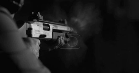 Photo for Monochrome shot of person firing a powerful shotgun and reloading shell bullet in black and white - Royalty Free Image
