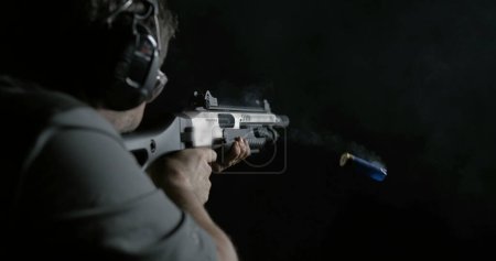 Photo for Man Firing Shotgun Captured in 800fps Super Slow-Motion, High-Speed Shooting from Behind - Royalty Free Image