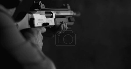 Photo for Monochrome shot of person firing a powerful shotgun and reloading shell bullet in black and white - Royalty Free Image