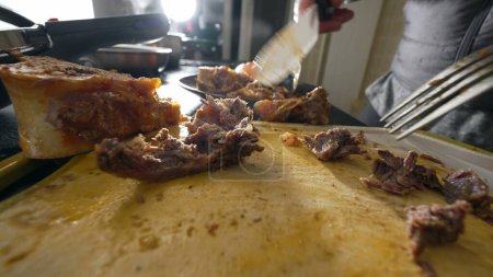 Foto de Detalle de la toma de carne que se prepara con cuchillo y tenedor, Primer plano de la trituración individual de carne para cocinar alimentos - Imagen libre de derechos