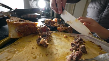 Foto de Detalle de la toma de carne que se prepara con cuchillo y tenedor, Primer plano de la trituración individual de carne para cocinar alimentos - Imagen libre de derechos