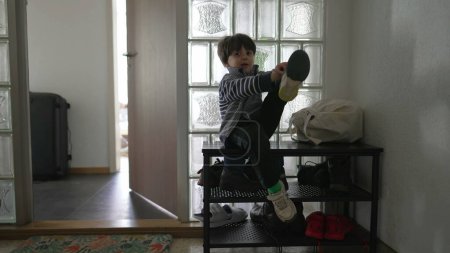 Photo for Little one fastening footwear by entrance, kid setting off, sliding into shoes, candid family lifestyle of child getting getting ready to go out, putting shoes - Royalty Free Image