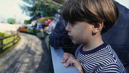 Téléchargez les photos : Enfant observateur jouissant d'une vue, penché du wagon miniature en mouvement du Swiss Vapeur Park - en image libre de droit