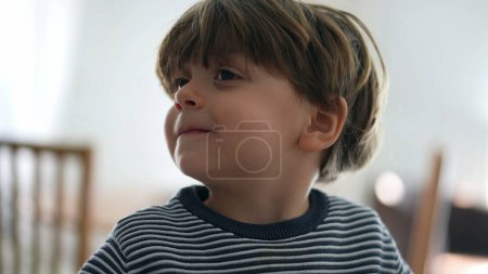 Foto de Pequeño niño sacudiendo la cabeza en la negación mientras sonríe, retrato de primer plano cara de niño feliz diciendo NO con el lenguaje corporal negarse a ofrecer - Imagen libre de derechos
