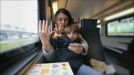Photo for Dedicated mom imparting counting lessons to her child on a train, exemplifying mobile education and the role of a hands-on parent - Royalty Free Image