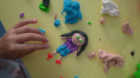 Téléchargez les photos : Moules pour enfants Formes imaginées de Play Clay, mains d'enfant en gros plan créant des figures de bâton avec de l'argile vue d'en haut, créativité imaginative - en image libre de droit