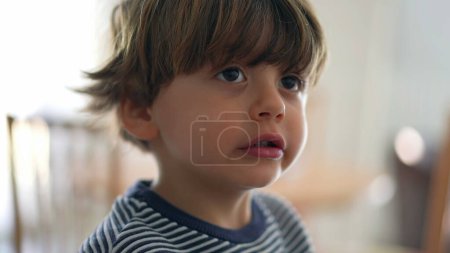 Foto de Niño masticando comida con boca ancha abierta, cara de primer plano de niño comiendo comida masticable, masticación cocnept en concentración profunda - Imagen libre de derechos