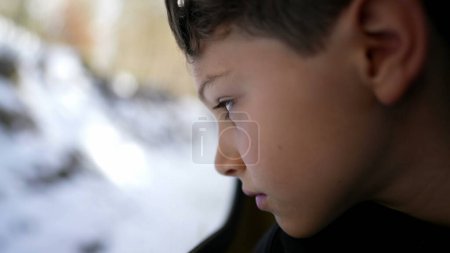 Téléchargez les photos : Voyage en train Contemplation du regard réfléchi de l'enfant sur le paysage tout en s'appuyant sur la fenêtre du train - en image libre de droit
