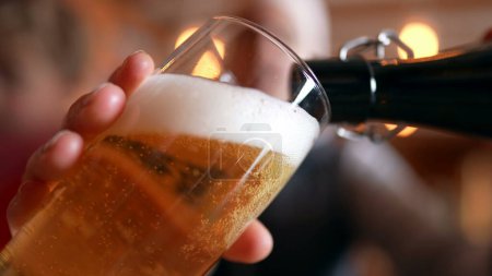 Foto de Copa de llenado con cerveza en el restaurante, tradicional vertido de oro, cara de primer plano con bebida refrescante - Imagen libre de derechos