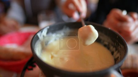 Photo for Fondue close-up of fork serving bread with cheese - Eating traditional Swiss cuisine - Royalty Free Image