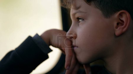 Photo for Lost in Thought of Pre-Teen Boy by Train Window, Melancholic Journey - Pensive Child's Profile Gaze - Royalty Free Image