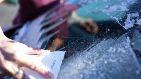Foto de Preparación temprana de viaje - Mano raspar coche parabrisas escarcha con herramienta - Imagen libre de derechos
