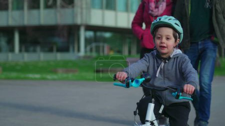Foto de Bicicleta infantil con casco protector durante la temporada de otoño. Feliz niño pequeño haciendo ejercicio al aire libre siendo activo - Imagen libre de derechos