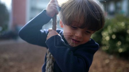 Photo for Joyful Child Firmly Gripping and Descending Wire Rope Slide at Public Park in Autumn Fall. Small Boy Gleefully Sliding Down Wire Rope Between Trees in Park - Royalty Free Image