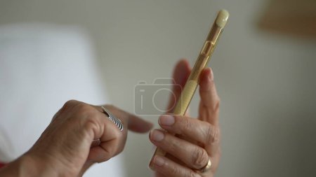 Photo for Close-up senior hands holding cellphone device, finger touching screen selecting item online - Royalty Free Image