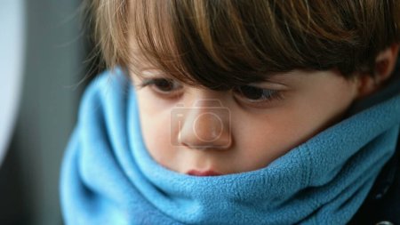 Photo for Close-up of a contemplative young caucasian boy, ensconced in a scarf, reflecting a depth of introspection, encapsulating a profound meditative state - Royalty Free Image