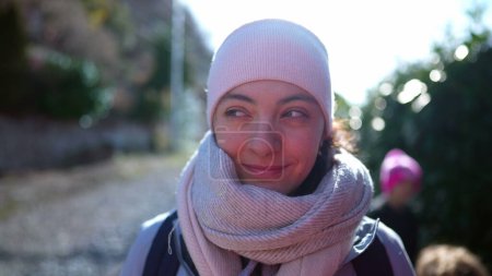 Foto de Retrato de una mujer feliz usando bufanda y gorro durante la estación fría, cara de cerca de una persona femenina caucásica de 30 años sonriendo - Imagen libre de derechos