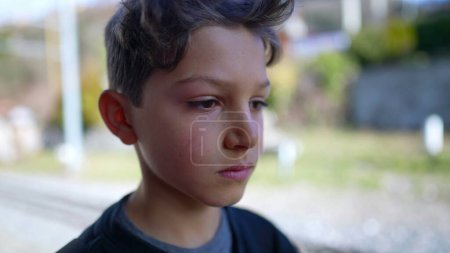 Téléchargez les photos : Sérieux jeune garçon gros plan face à la caméra debout à l'extérieur - en image libre de droit