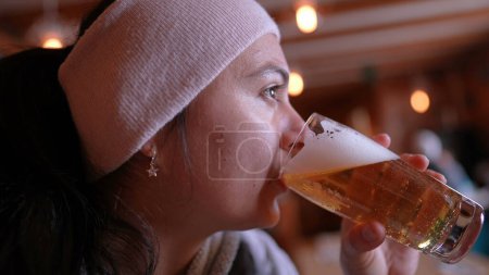 Foto de Beber Brew clip de invierno de la mujer disfrutando de la cerveza en el restaurante de temporada fría, perfil de cerca persona bebe refrescante cerveza de barril tradicional - Imagen libre de derechos