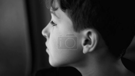 Photo for Sad depressed pre-teen male child traveling staring by window in contemplation. Pensive kid profile face close-up - Royalty Free Image