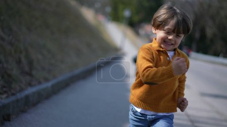 Photo for Front view of joyful child running forward toward camera - Royalty Free Image