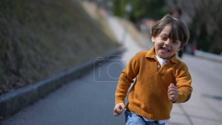 Photo for Front view of joyful child running forward toward camera - Royalty Free Image