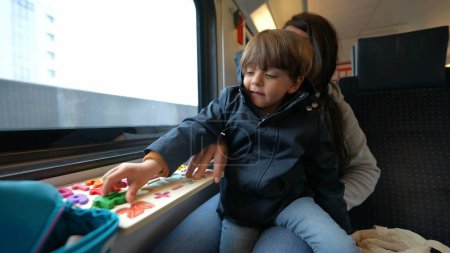 Photo for Engaged mother conducting a learning session with her child aboard a high-speed train, illustrating mobile childhood education - Royalty Free Image
