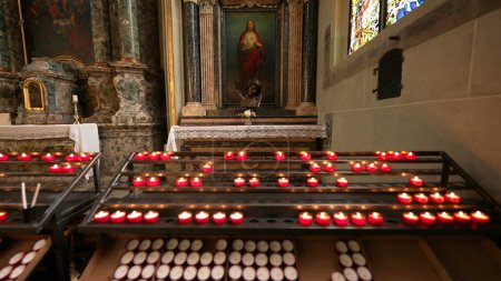 Téléchargez les photos : Fribourg, Suisse Vers mars 2022 - Peinture de Jésus-Christ à l'intérieur de la cathédrale Saint-Nicolas, refuge spirituel à l'intérieur d'un pilier catholique avec des bougies allumées pour le culte - en image libre de droit