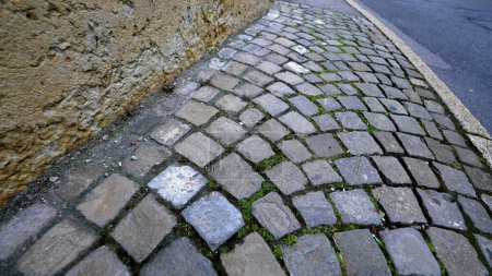 Téléchargez les photos : Rue pavée antique, détail gros plan du trottoir en pierres anciennes dans le sentier traditionnel en mouvement - en image libre de droit