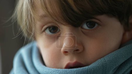 Téléchargez les photos : Portrait d'un petit garçon caucasien orné d'une écharpe, profondément imprégné de pensée, exsudant un profond sens de réflexion et d'introspection - en image libre de droit