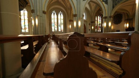 Téléchargez les photos : Architecture ancienne et bancs, détails de l'espace de culte catholique ? Design spirituel avec sièges traditionnels en bois - en image libre de droit
