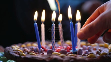 Foto de Las velas de cumpleaños se encienden encima de la torta durante la celebración de la fiesta infantil - Imagen libre de derechos
