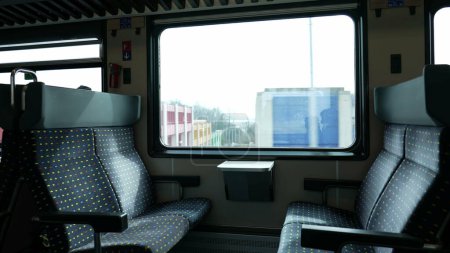 Photo for Empty train seats with nobody, landscape passing by in background. High-speed transportation - Royalty Free Image