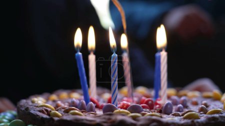 Foto de Las velas de cumpleaños se encienden encima de la torta durante la celebración de la fiesta infantil - Imagen libre de derechos