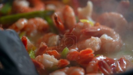 Téléchargez les photos : Cuisson des crevettes et des légumes à l'intérieur de la casserole, brassage des aliments et préparation des repas macro gros plan - en image libre de droit