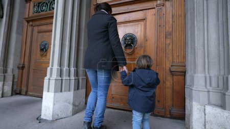 Téléchargez les photos : Mère et enfant entrant dans le temple sacré les mains jointes, Thème traditionnel du parent et de l'enfant allant à l'église - en image libre de droit