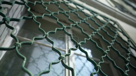 Téléchargez les photos : Fenêtre cage métallique avec des motifs protégeant le bâtiment contre les intrus. Protection de clôture - en image libre de droit
