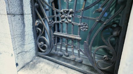 Téléchargez les photos : Bouclier élégant - Grille en métal de fenêtre antique avec ornements, élégant dissuasif pour l'entrée - en image libre de droit